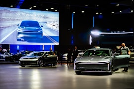 a group of people standing around a bunch of cars