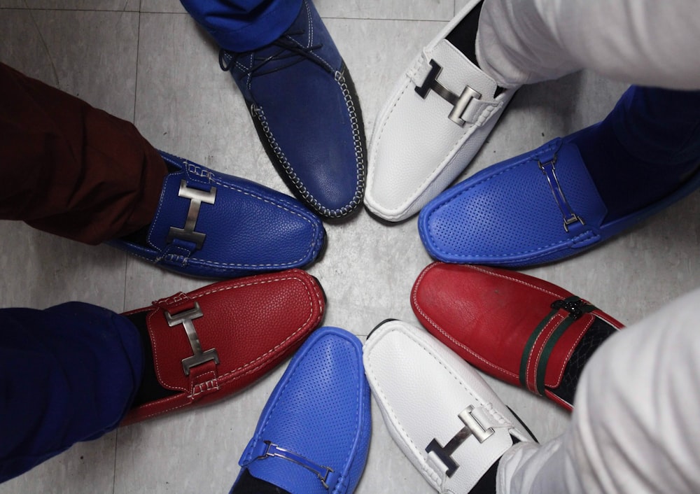 a group of people standing in a circle wearing shoes