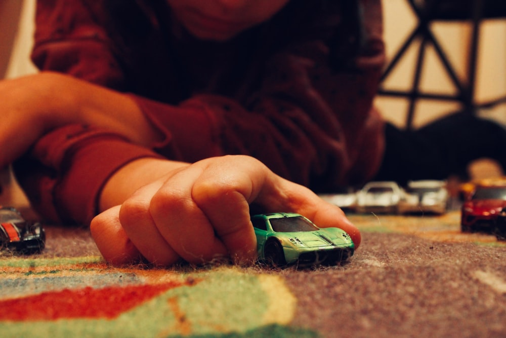 a child playing with toy cars on the floor