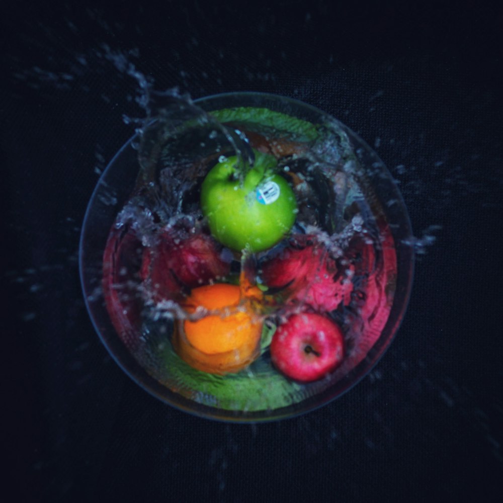 a bowl filled with fruit and water on top of a table