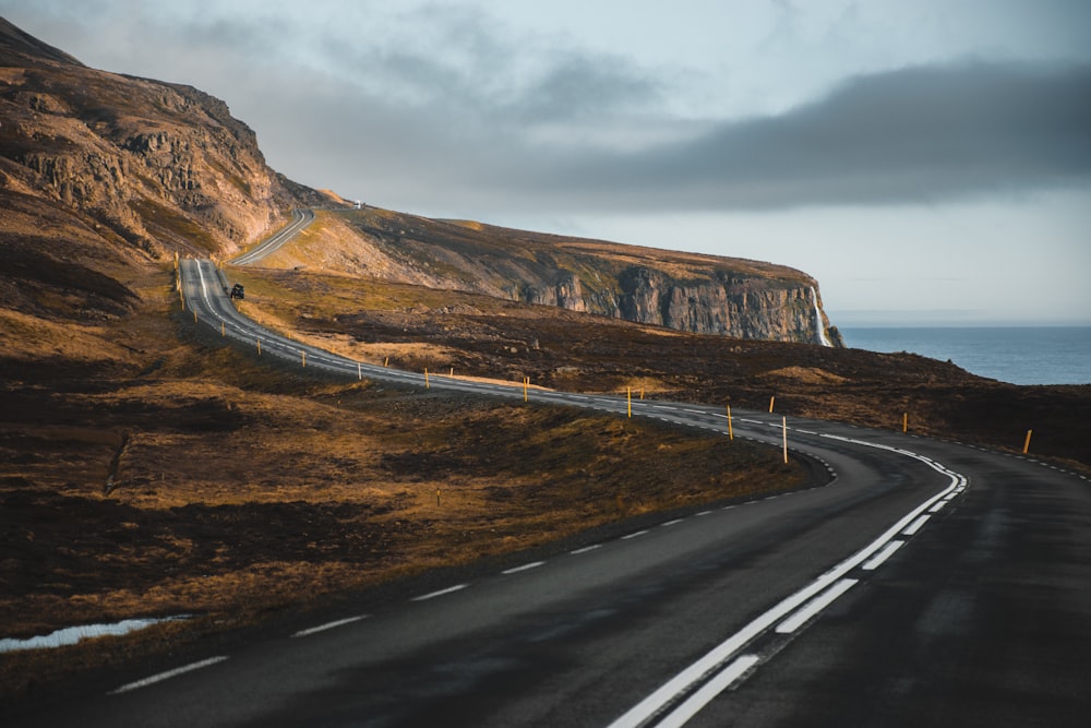 a long winding road with a mountain in the background