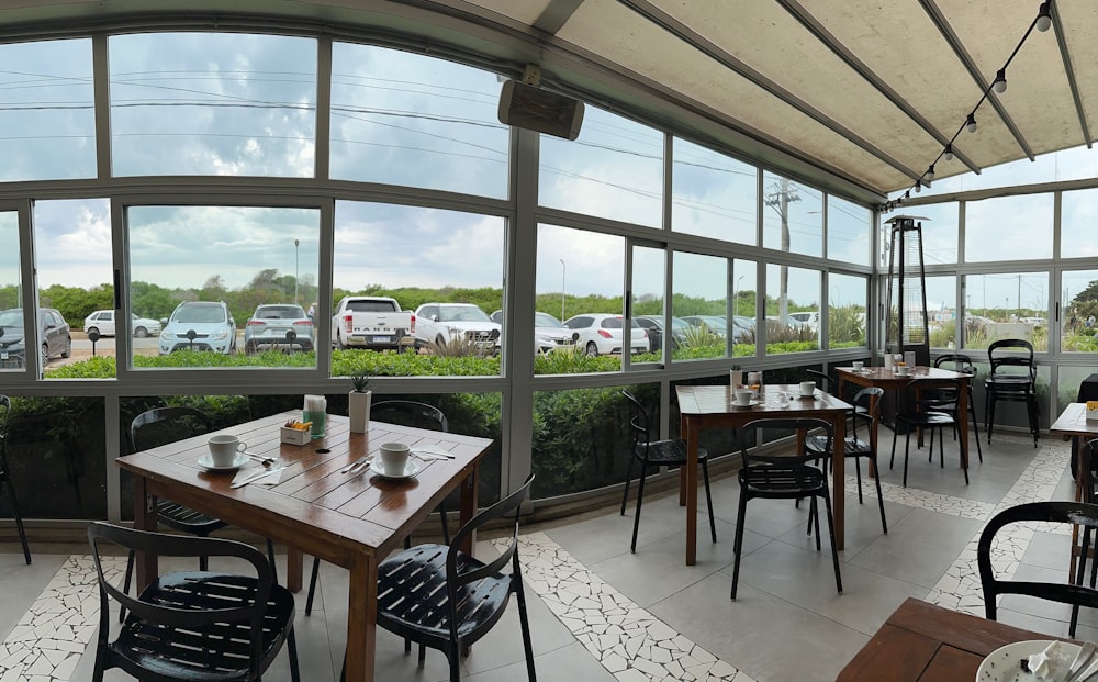 a restaurant with tables and chairs and a view of a parking lot