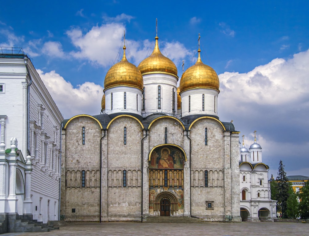 a large white building with gold domes on top of it