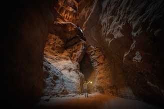 a man standing in a narrow tunnel in a mountain