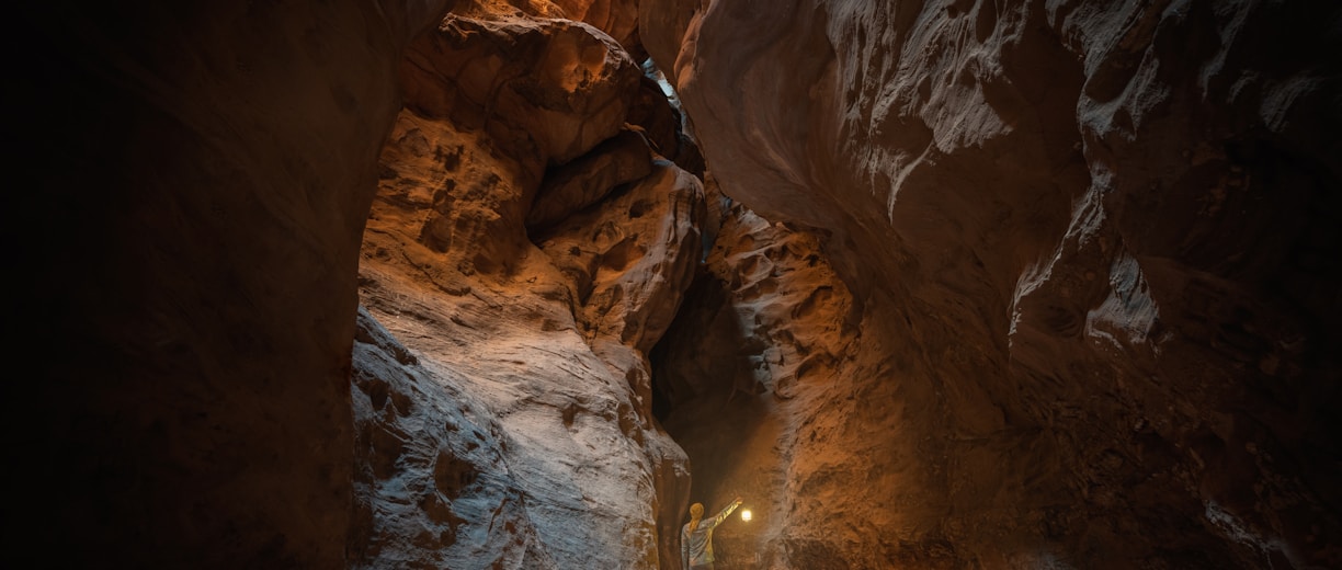 a man standing in a narrow tunnel in a mountain