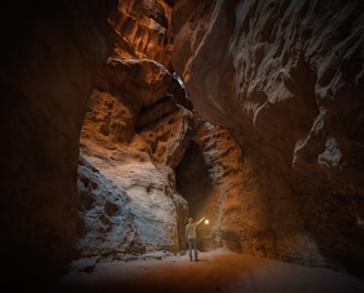 a man standing in a narrow tunnel in a mountain