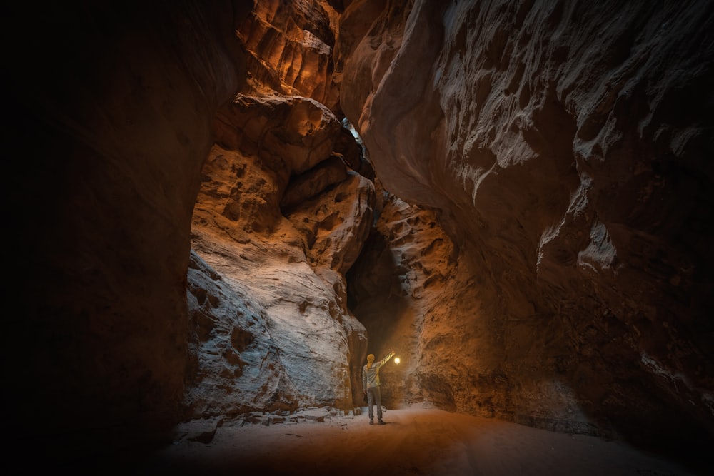 a man standing in a narrow tunnel in a mountain