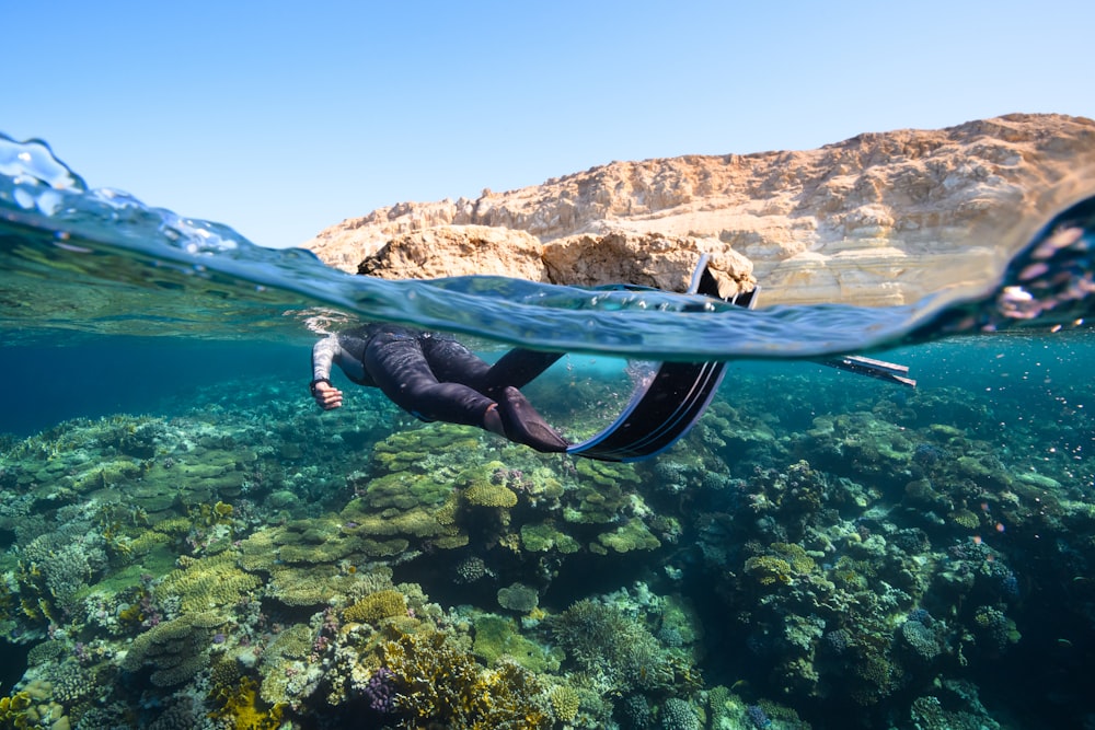 a person swimming in the ocean with a mountain in the background