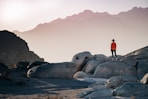 a person standing on top of a large rock