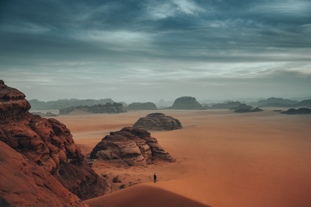 사막의 모래 언덕에 서 있는 사람