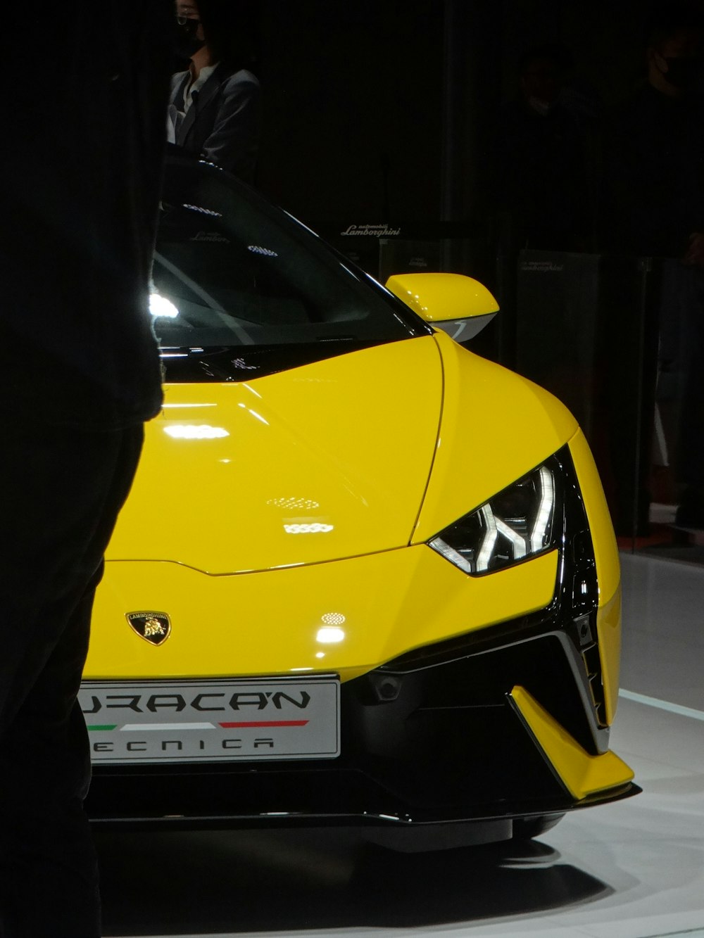 a man standing next to a yellow sports car