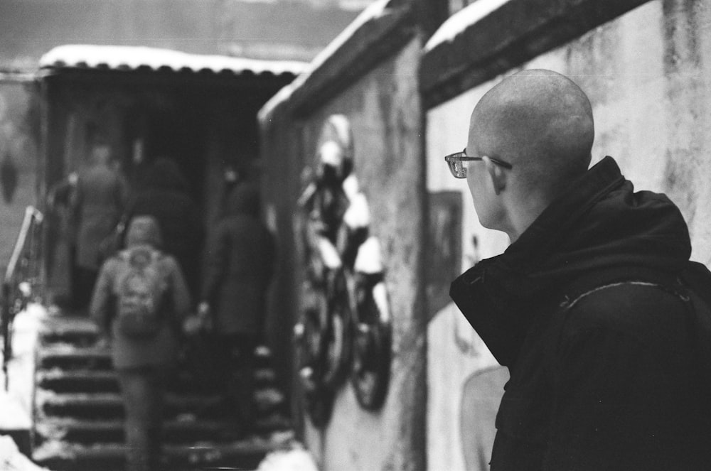 a man with a bald head standing in front of a building