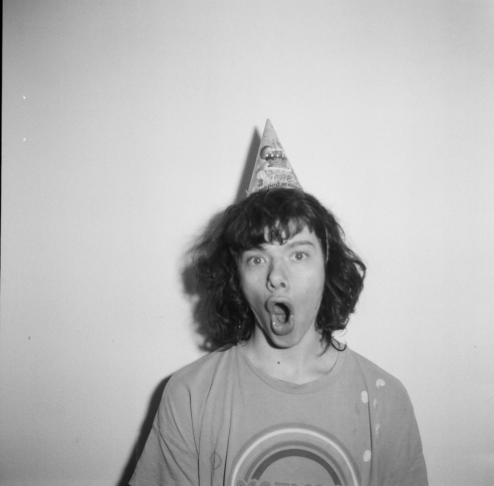 a young man with a party hat making a silly face