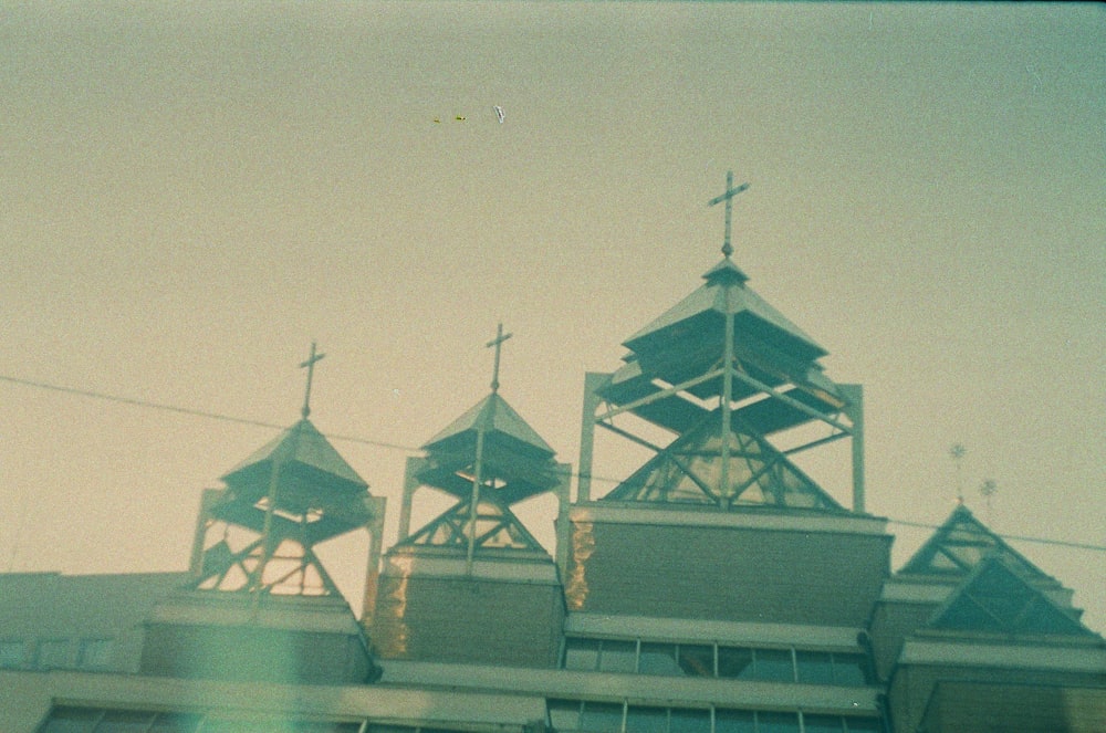 a building with three steeples and a cross on top