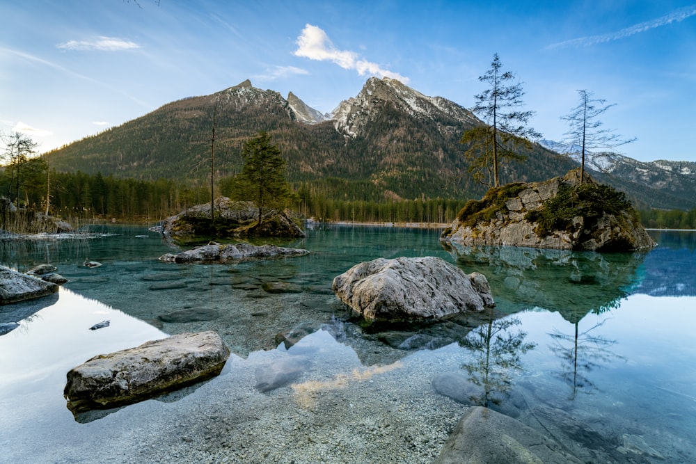 Una cadena montañosa se refleja en el agua de un lago