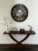 a wooden table with a clock on the wall