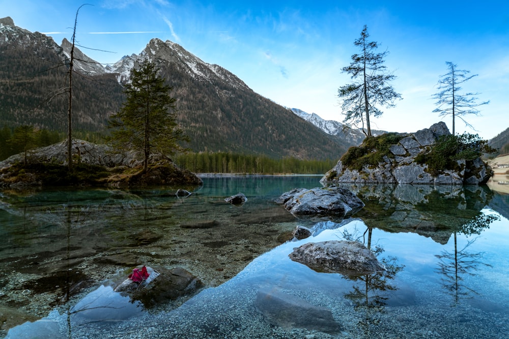 un plan d’eau entouré de montagnes et d’arbres