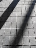 a shadow of a person walking on a sidewalk