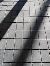 a shadow of a person walking on a sidewalk
