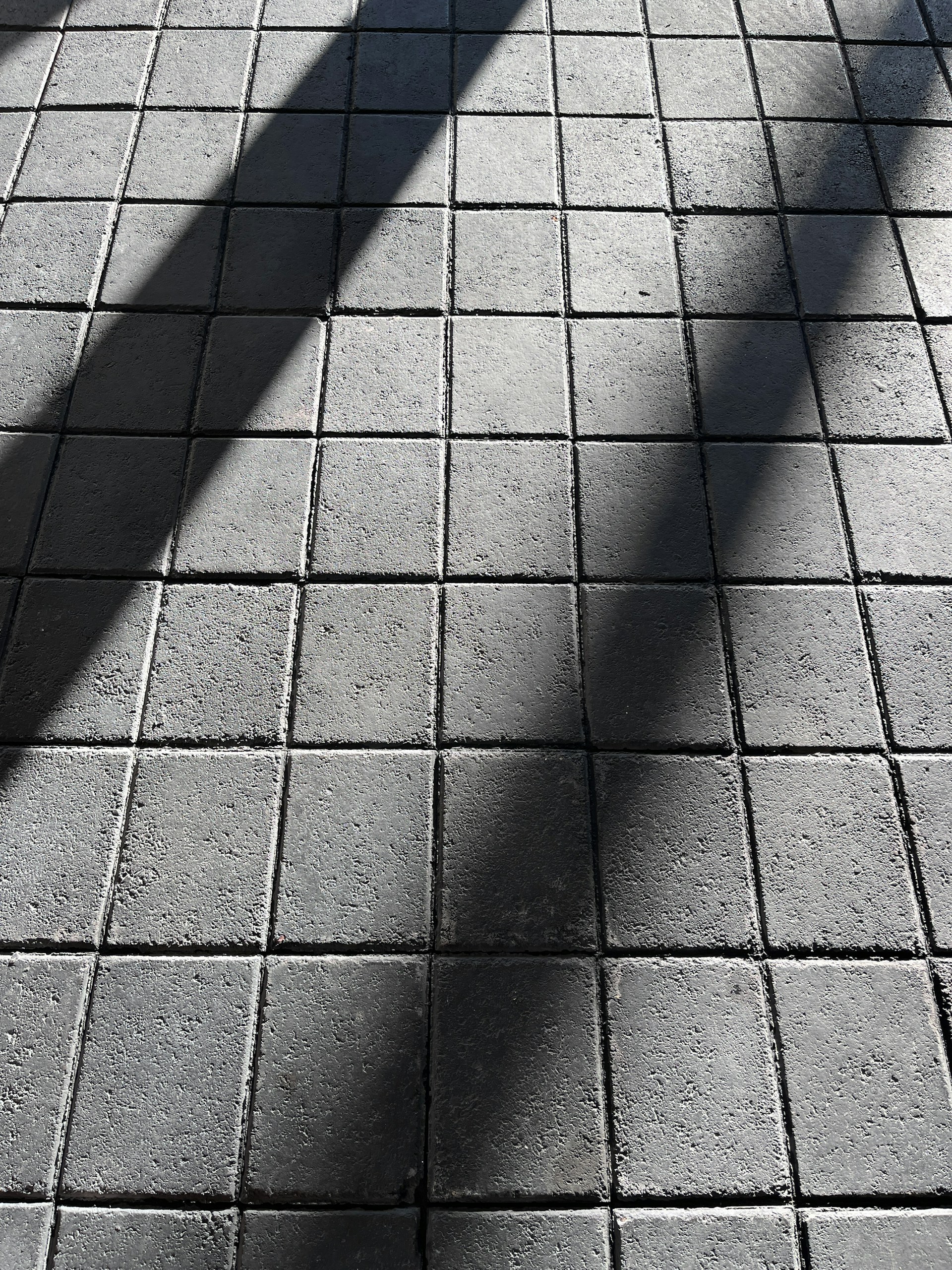 a shadow of a person walking on a sidewalk