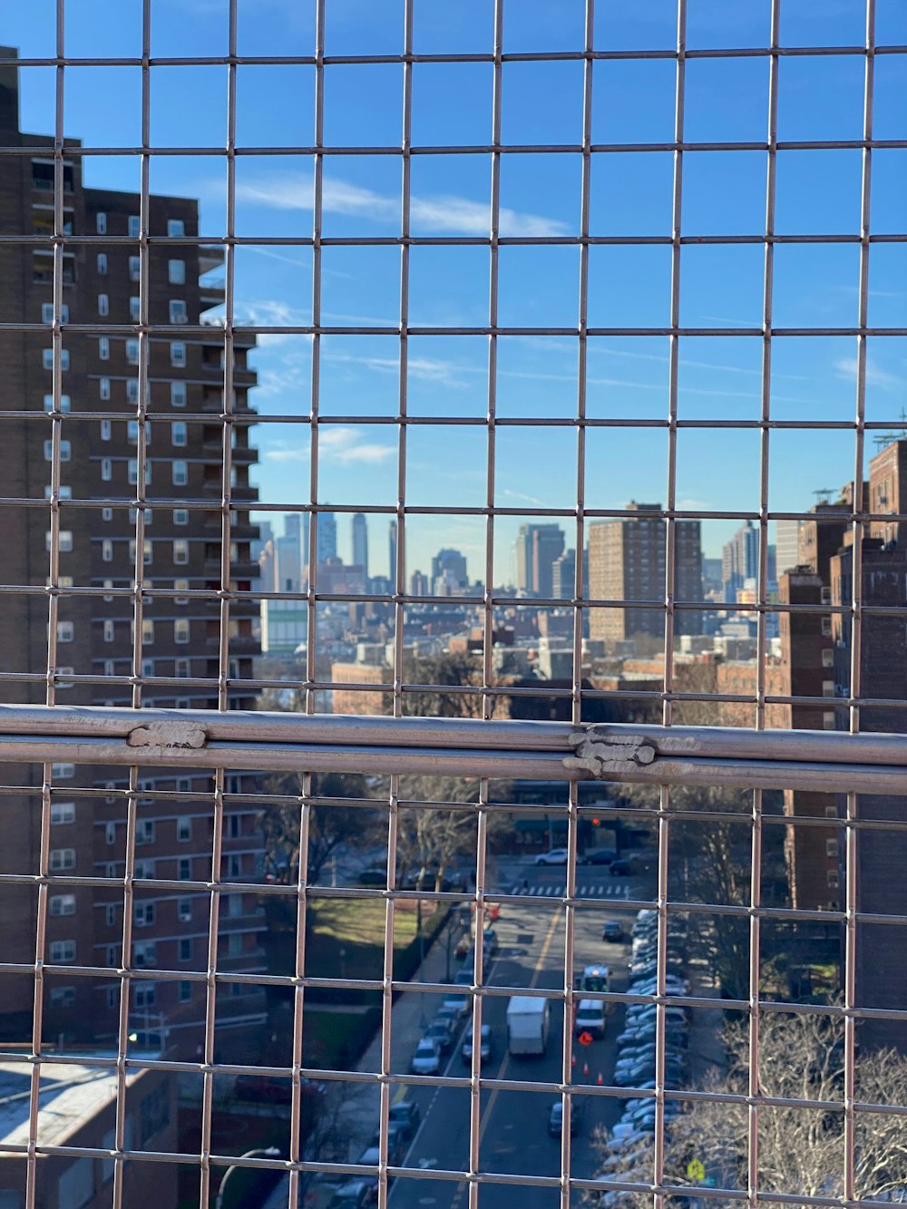 a view of a city through a fence