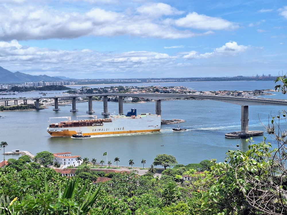 a large boat traveling down a river next to a bridge