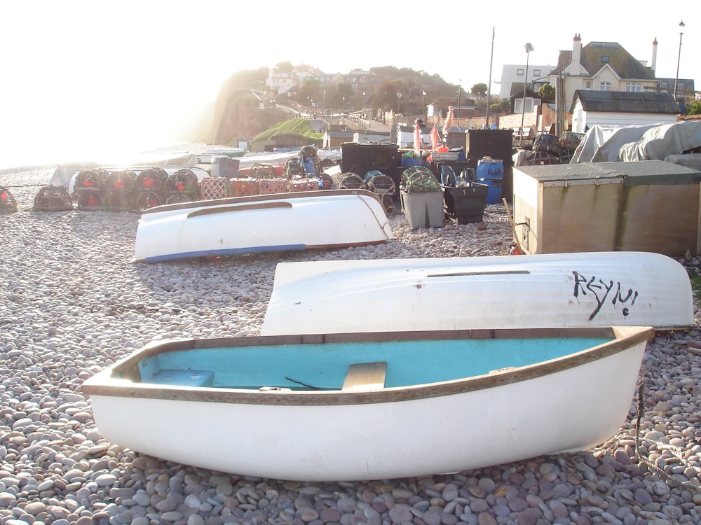 a couple of small boats sitting on top of a gravel field