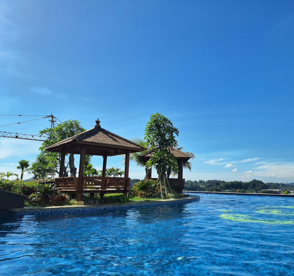 a gazebo sitting on top of a blue pool