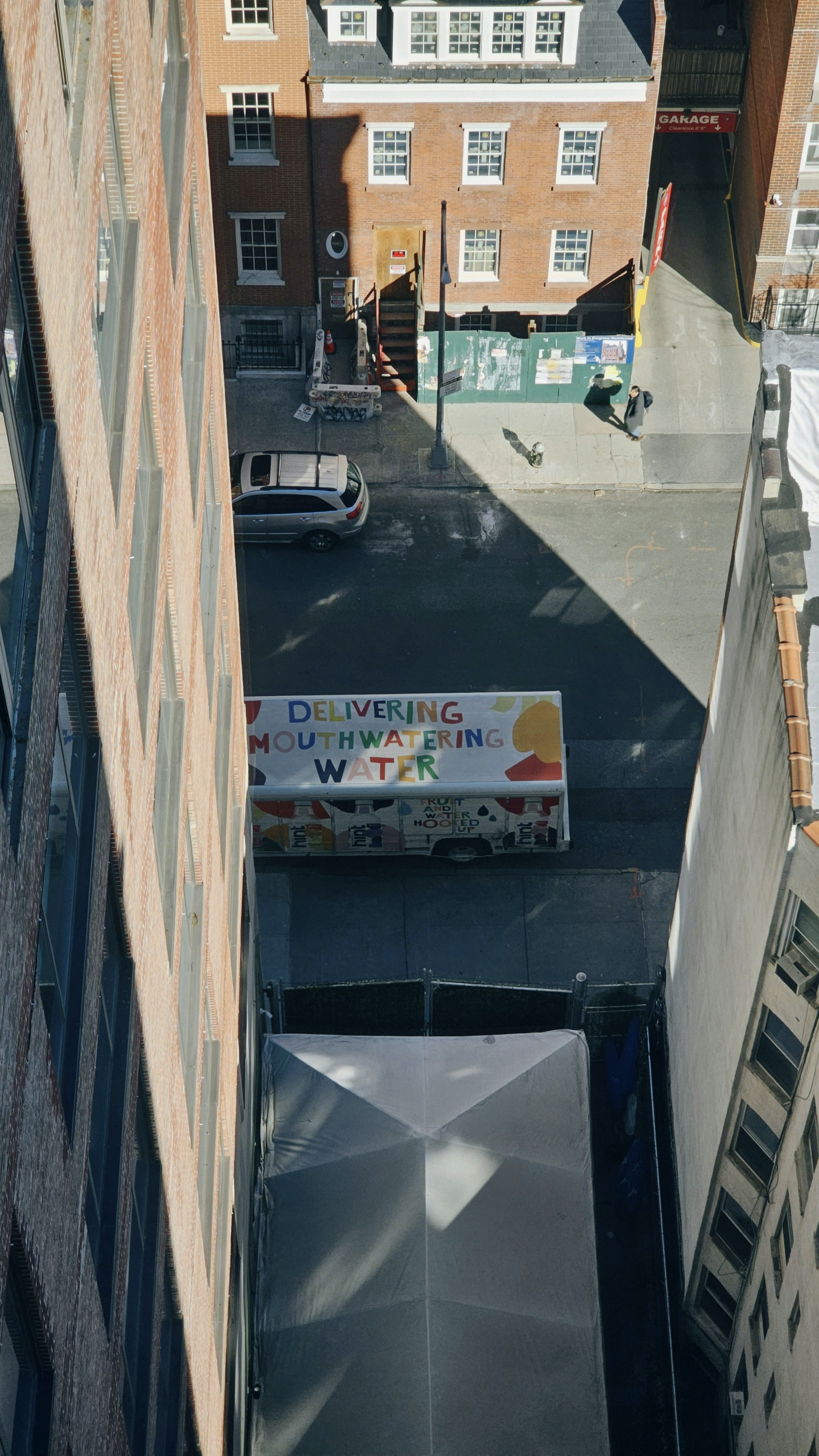 an overhead view of a city street with a sign on the side of a building