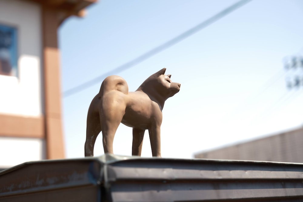 a statue of a dog on top of a dumpster