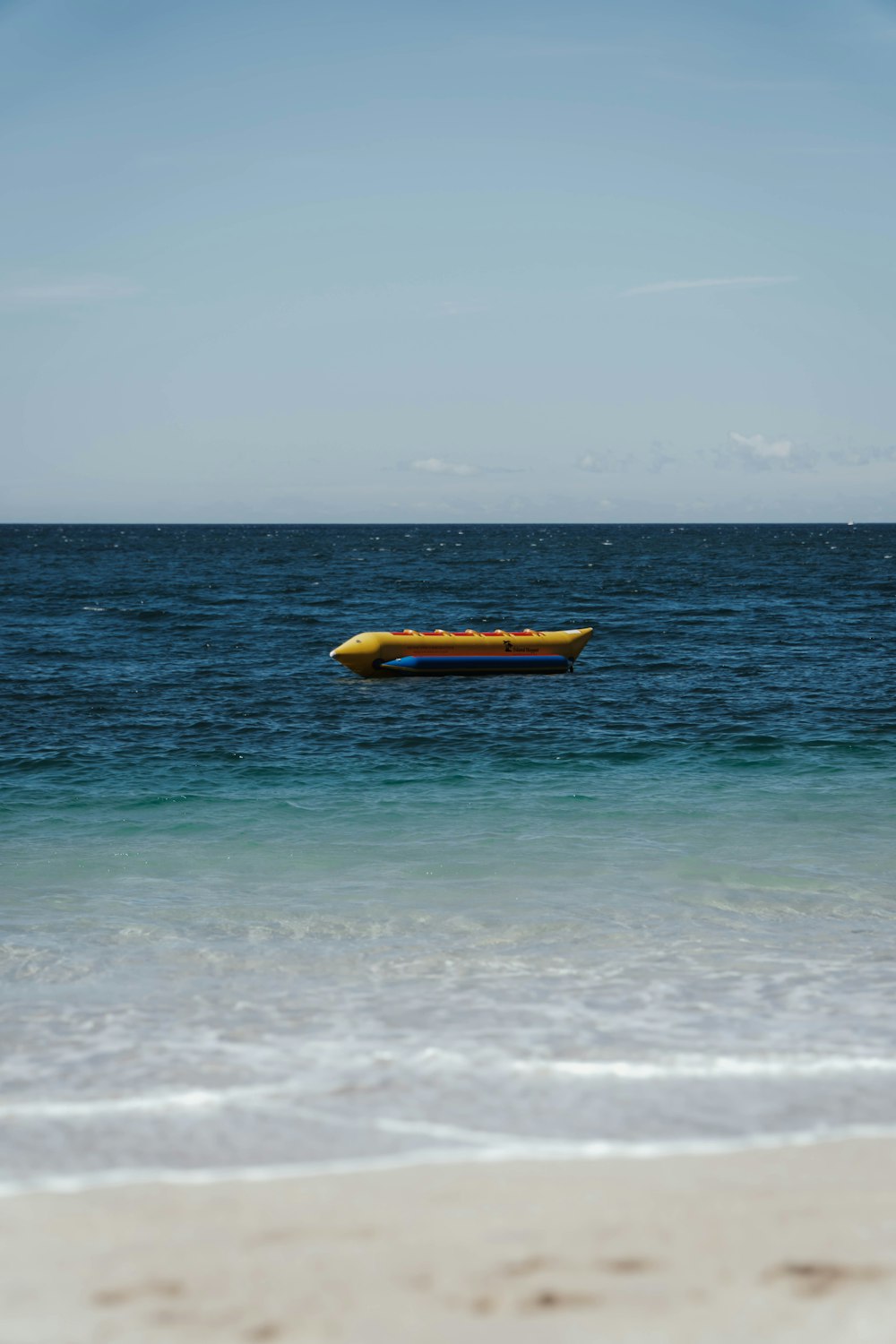 a yellow boat floating on top of a body of water