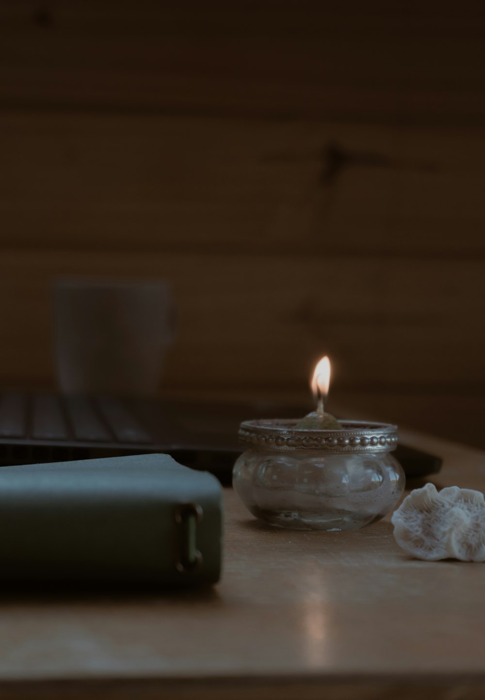 a lit candle sitting on top of a wooden table