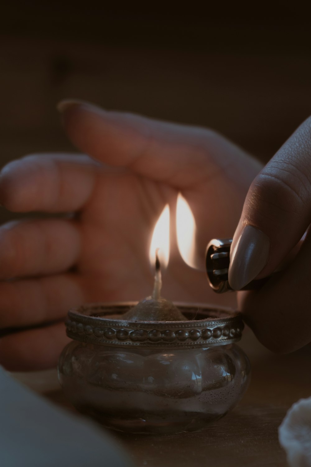 a person lighting a candle on a table