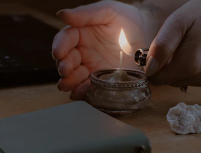 a person lighting a candle on a table