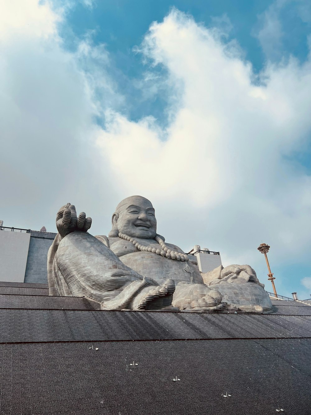 a large statue of a buddha on top of a building