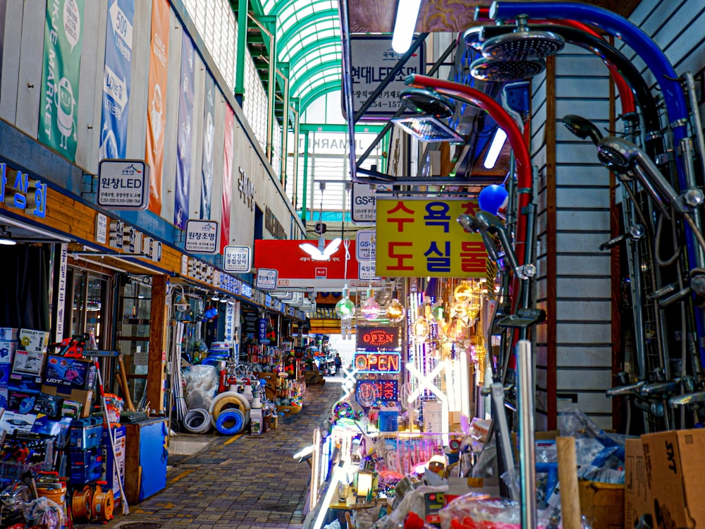 a narrow street with shops and signs on it