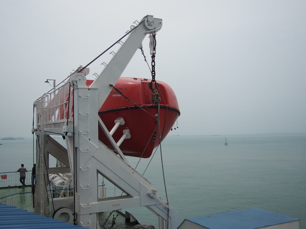 a red and white boat sitting on top of a body of water