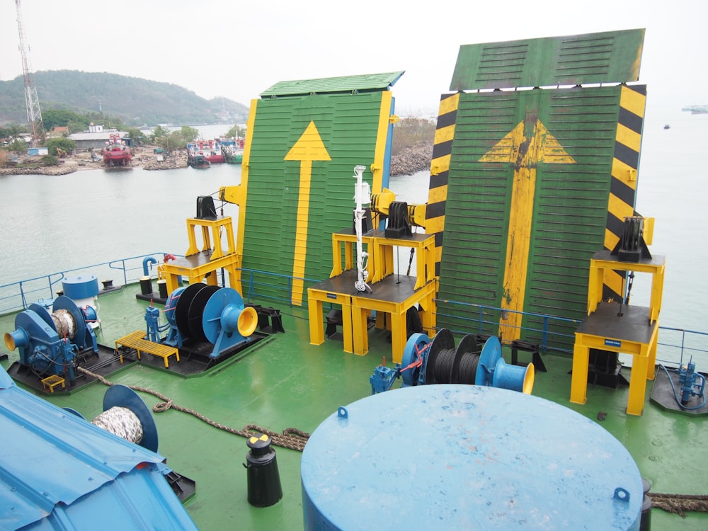 a green and yellow boat with a lot of equipment on it