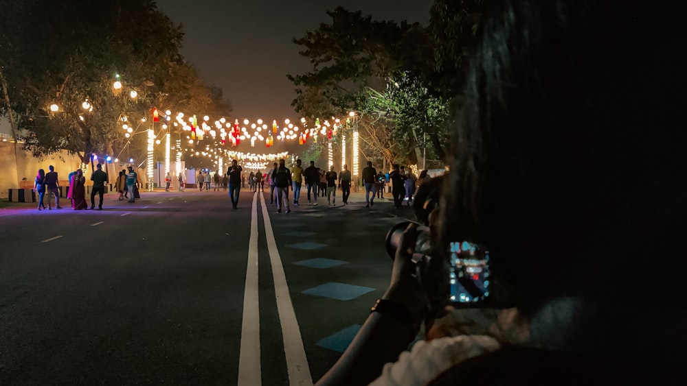 a group of people walking down a street at night