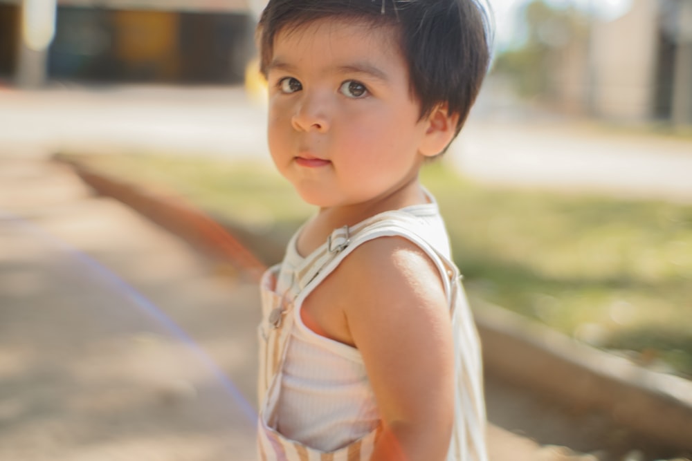 a little girl standing on a sidewalk with a frisbee in her hand