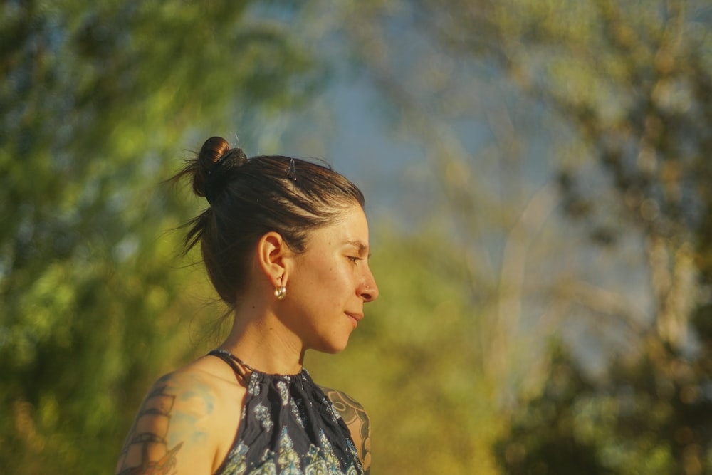 a woman with a tattoo on her arm looking away from the camera