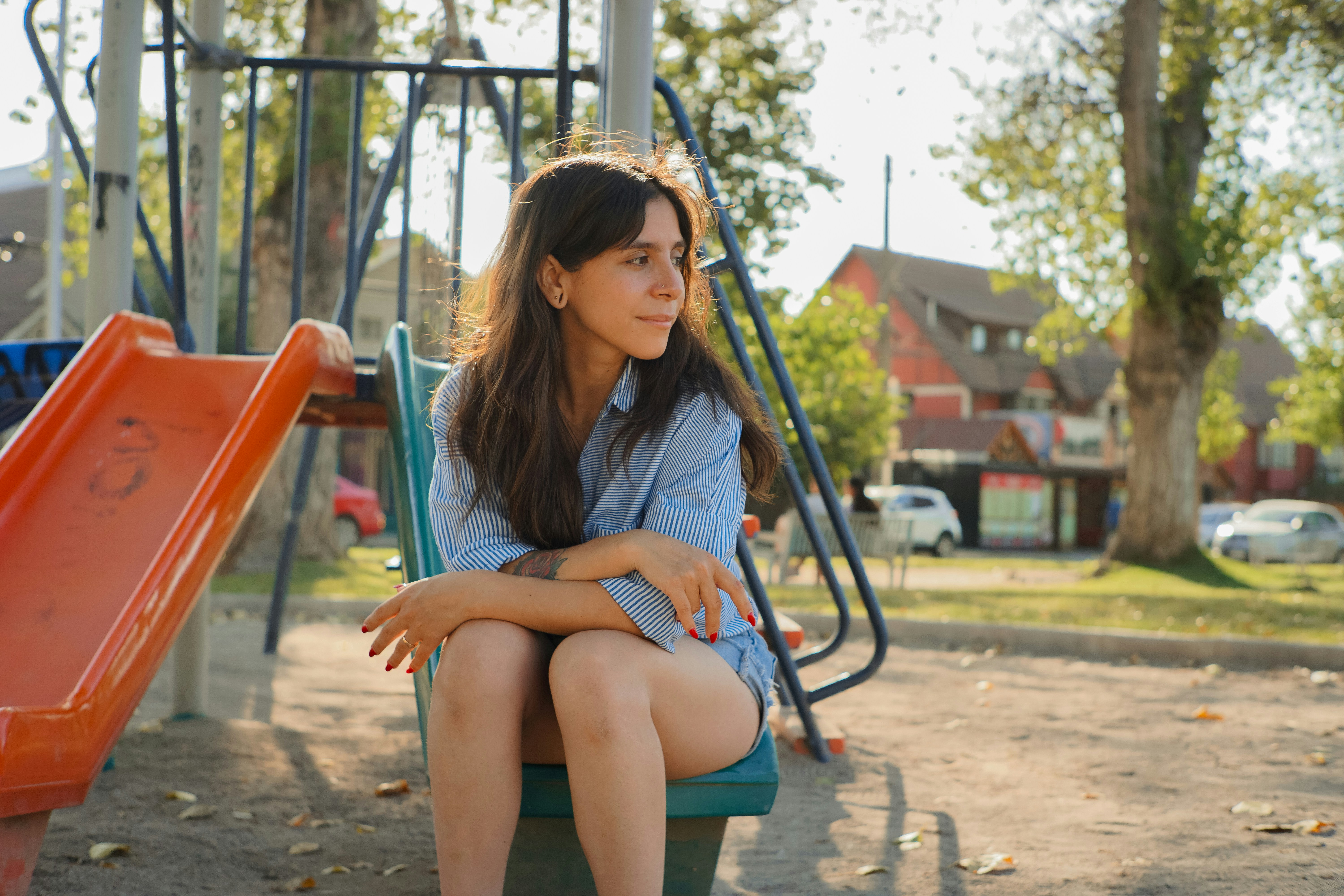 a woman sitting on a bench next to a playground