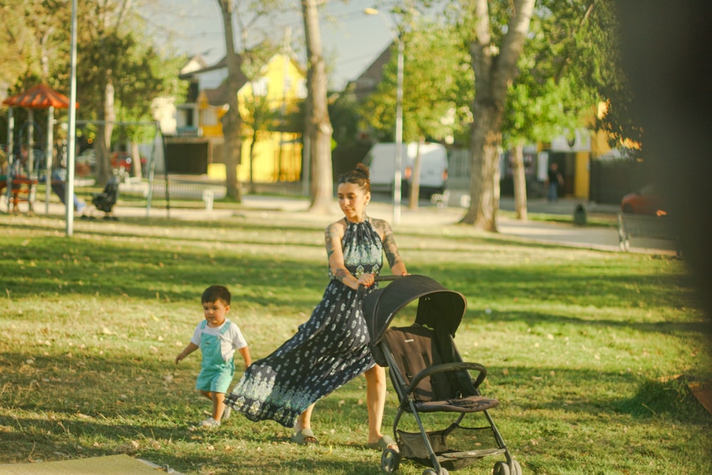 a woman pushing a stroller with a child in a park