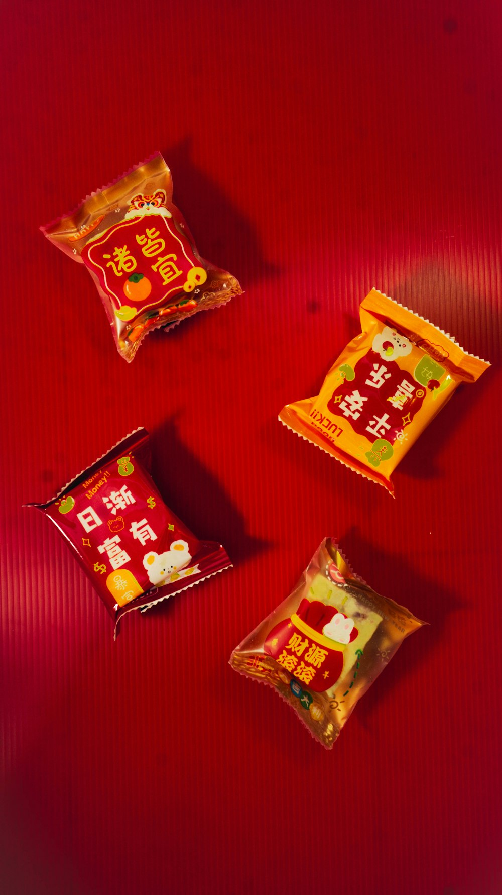three bags of food sitting on a red surface