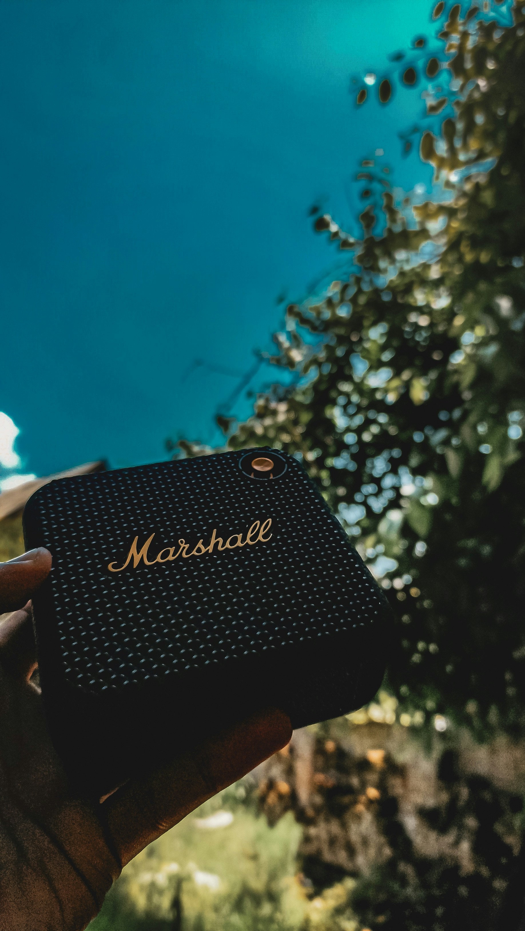 a hand holding a black box with a name on it