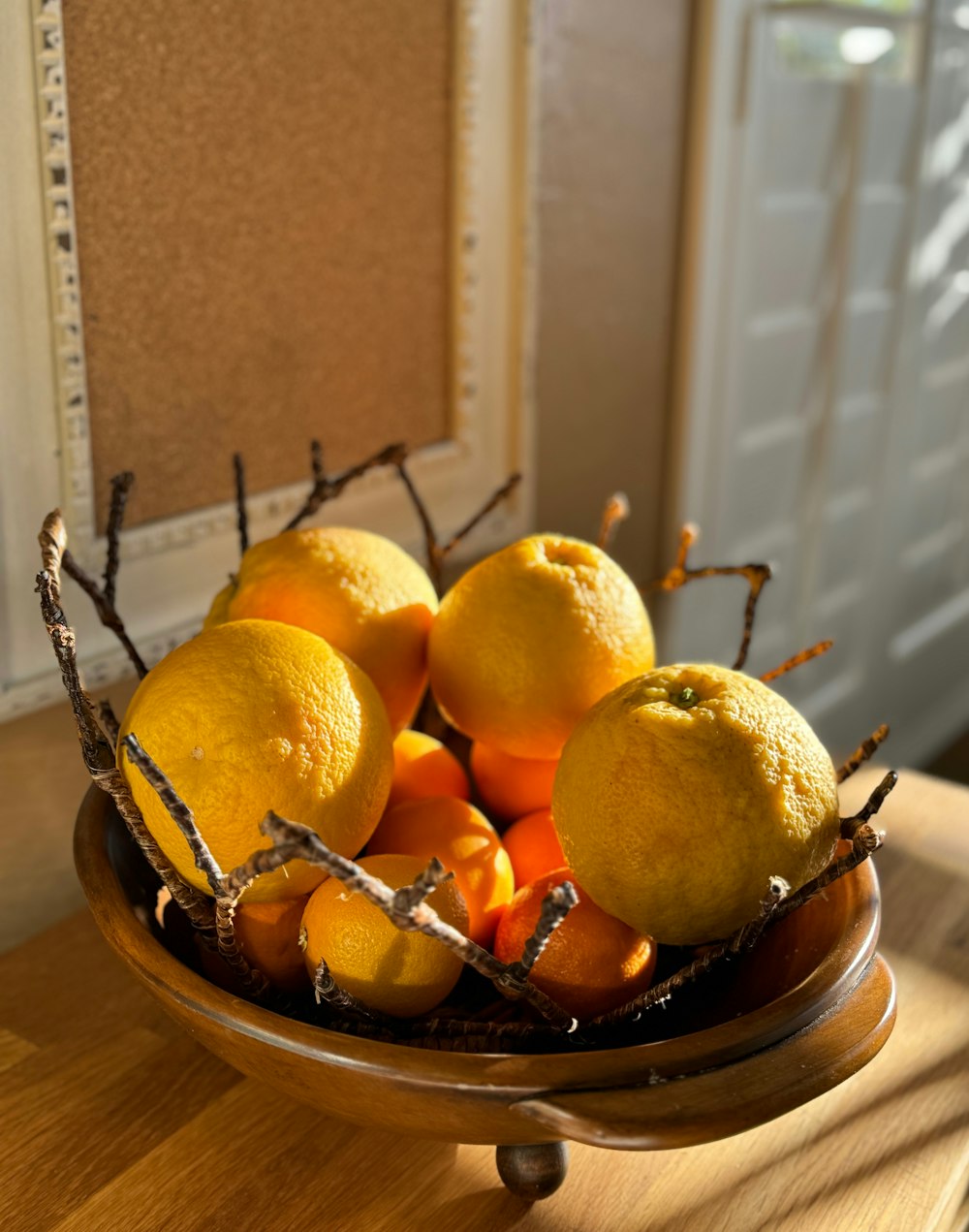 a bowl filled with oranges and lemons on a table