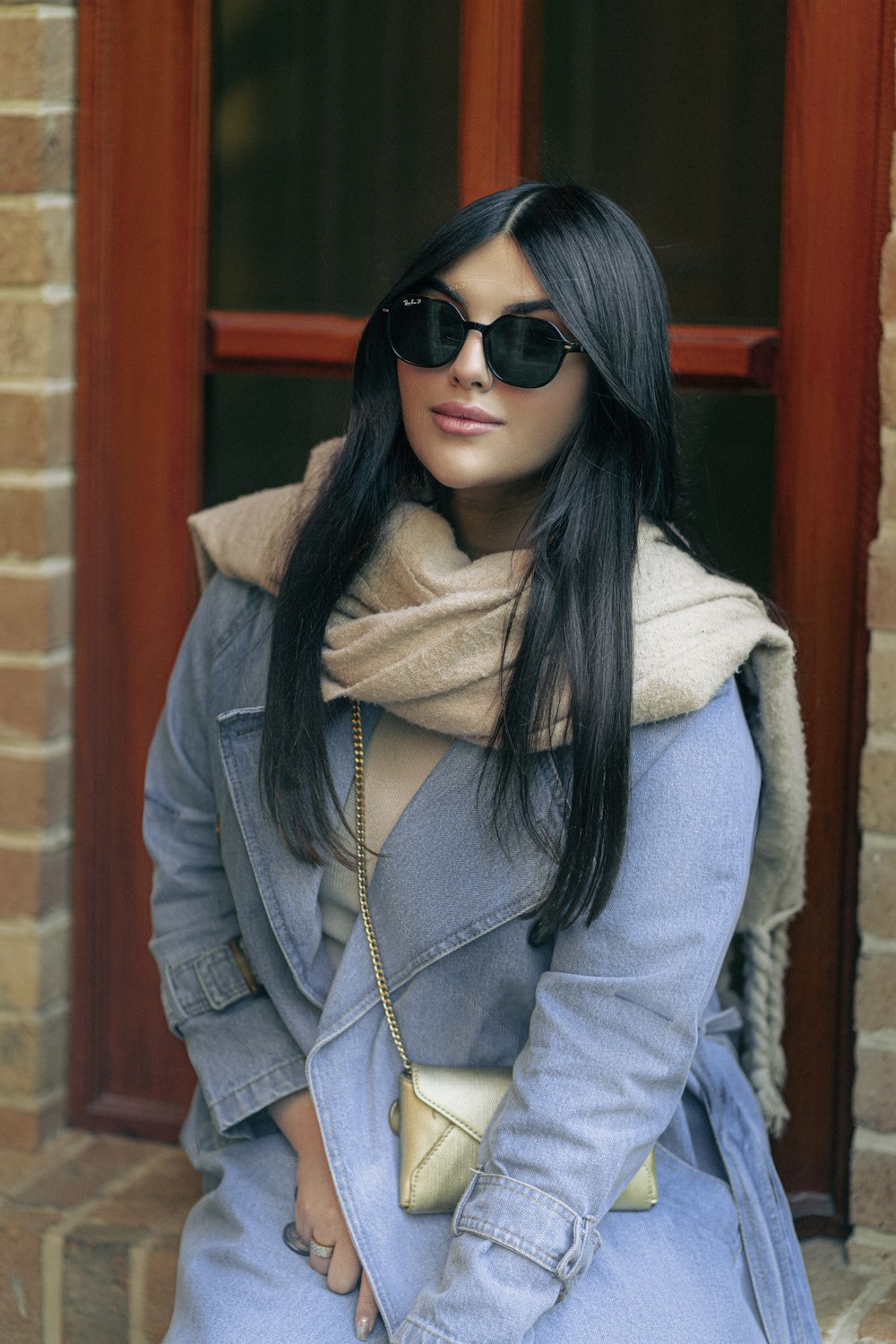 a woman sitting on a step wearing sunglasses
