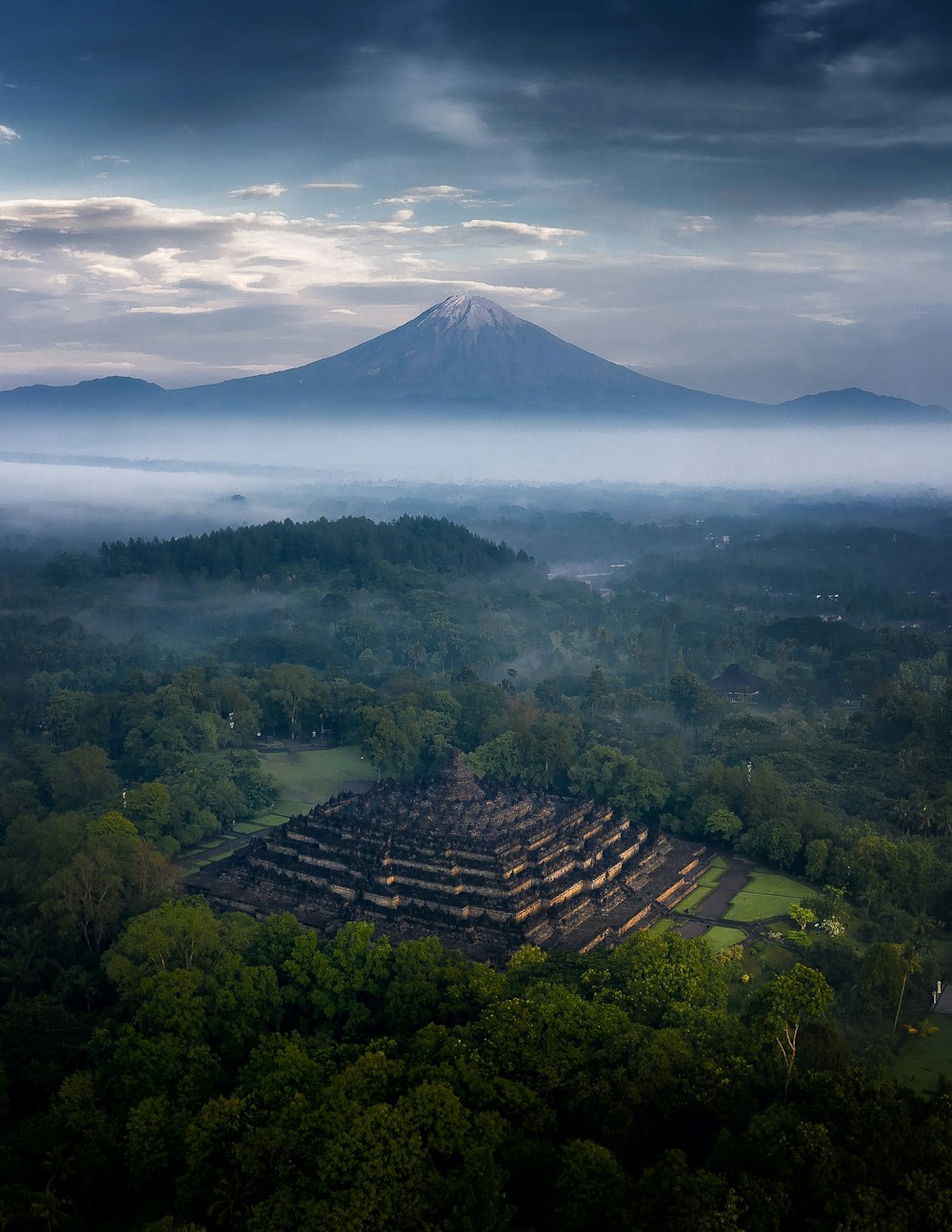 an aerial view of a large pyramid in the middle of a forest