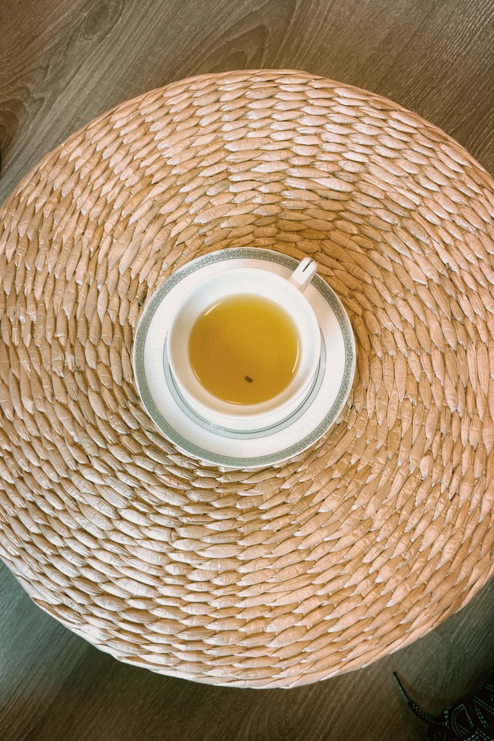 a cup of tea sitting on top of a straw hat