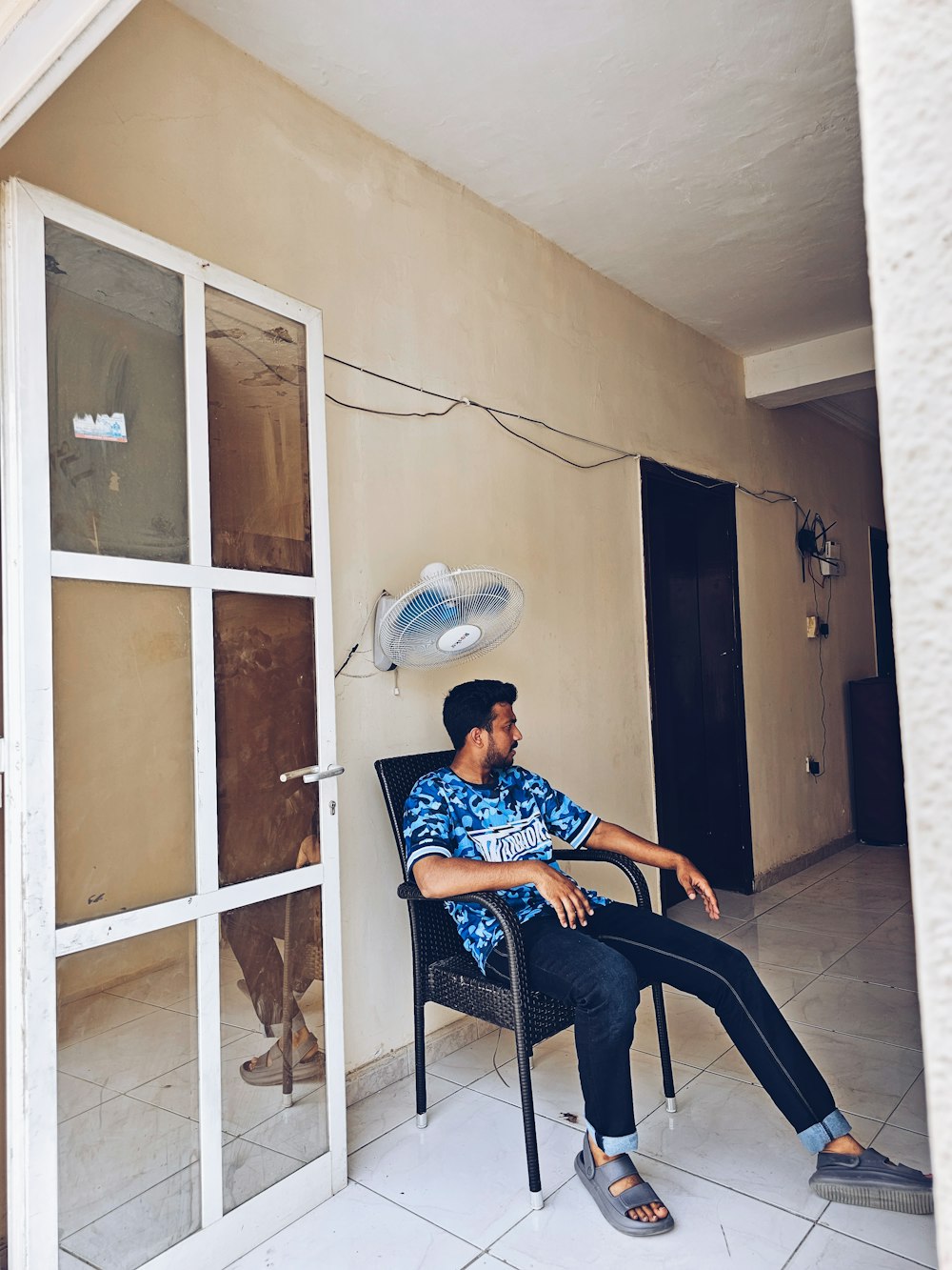 a man sitting in a chair with a hat on his head